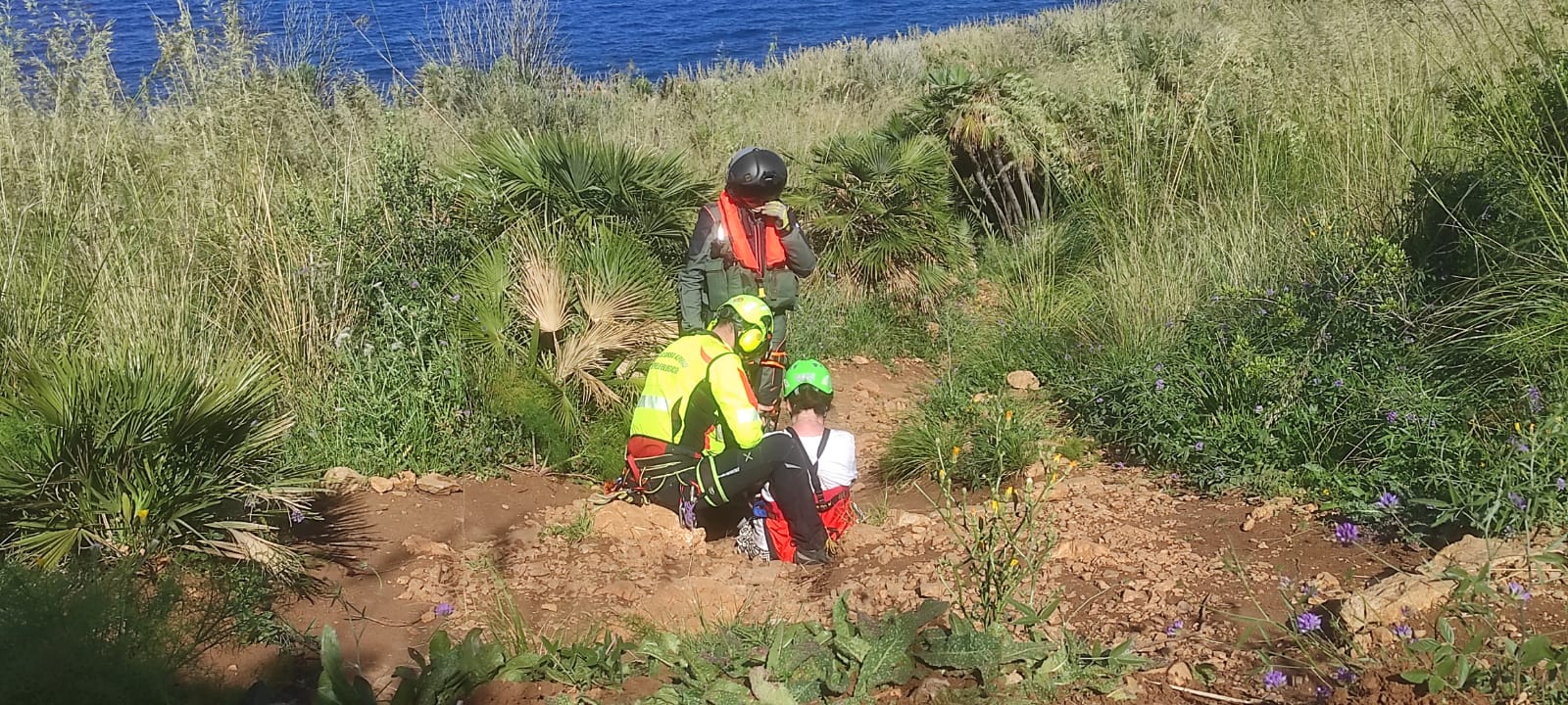 L'aerosoccorritore e un membro del Soccorso Alpino e Speleologico Siciliano preparano la donna infortunata per il recupero.